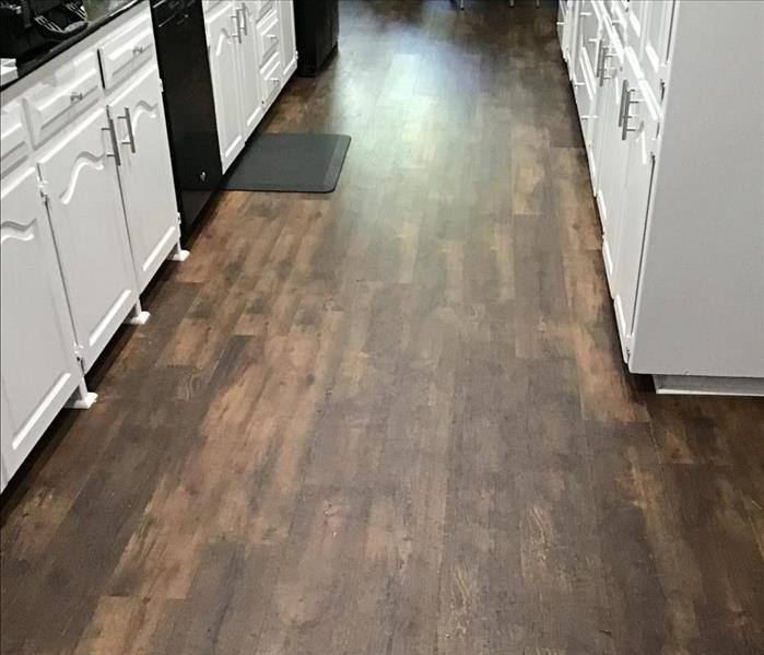 wooden floor in a kitchen with white cabinets