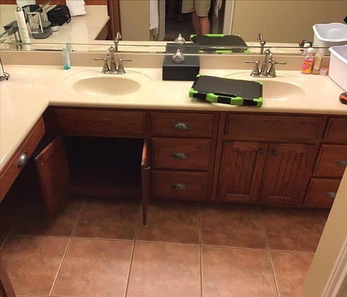 above angled view of a bathroom sink and its cabinets with one set open