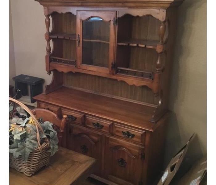 a wooden china cabinet with empty shelves