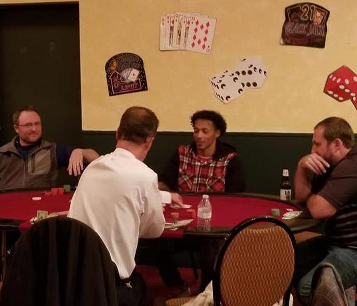 Four men sitting around a poker table playing poker