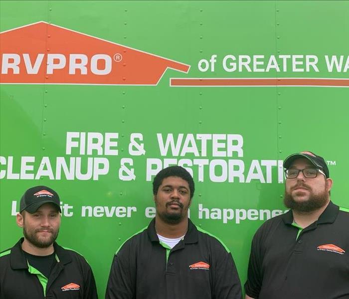 SERVPRO production crew in front of a company SERVPRO green production vehicle