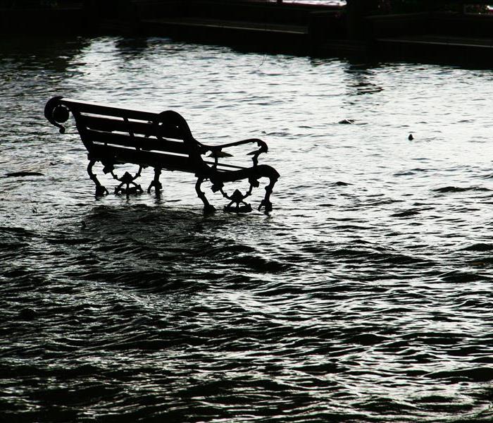 flood waters surround a metal park bench